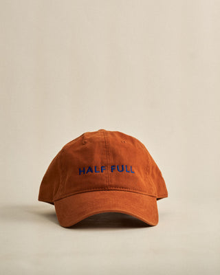 Brown cap with 'HALF FULL' text on a beige background