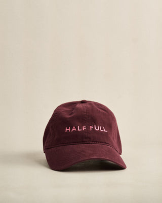Maroon cap with 'HALF FULL' text on a beige background