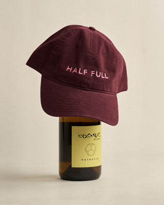 Maroon cap with 'HALF FULL' text on a bottle of Cosmic Wines.